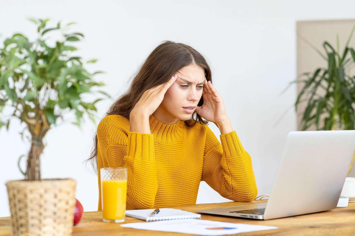 Frau mit Unterzuckerung hält sich die Stirn